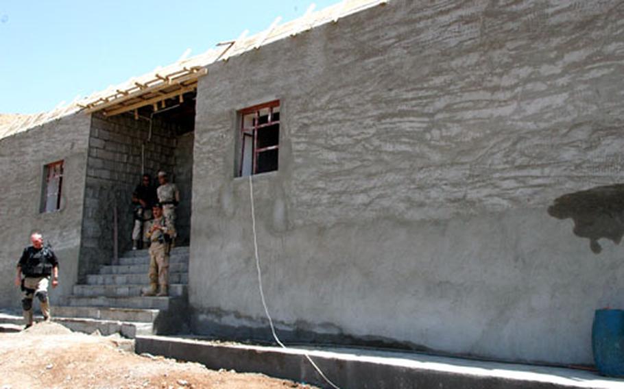 Members of an Erinys personal security detail, in black, and two policemen guard a border fort construction site during an Aug. 2 Corps of Engineers Gulf Region site visit.