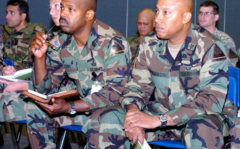 Sgt. Maj. Glenn Gibbs, left, and Lt. Col. Curtis Anderson, both of 1st Armored Division, listen to planners from the 21st Theater Support Command explain how USAREUR units and equipment will be transported to Afghanistan and Iraq during their next rotations.