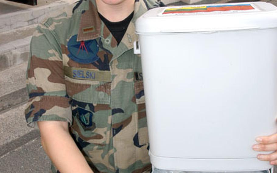 2nd Lt. Jenna Sielski, 35th Civil Engineer Squadron environmental flight pollution prevention chief, displays one of the new recycling bins to be distributed to base housing residents.