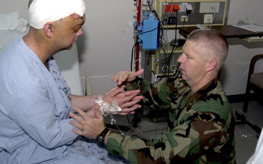 First Lt. Greg Carey, left, performs a resistance drill with his hands during a physical therapy session last week at Landstuhl Regional Medical Center, Germany, with Maj. Ford David Paulson, a physical therapist at the hospital.