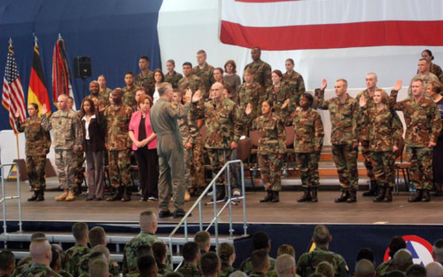 Chairman of the Joint Chiefs of Staff Air Force Gen. Richard B. Myers re-enlists 10 soldiers at a ceremony at Wiesbaden Army Airfield, Germany on Monday morning. Myers, along with NFL great Gale Sayers, comedians Jeff Ross and Colin Quinn and model Leeann Tweeden, is visiting troops on a 10-day, 10-country trip.