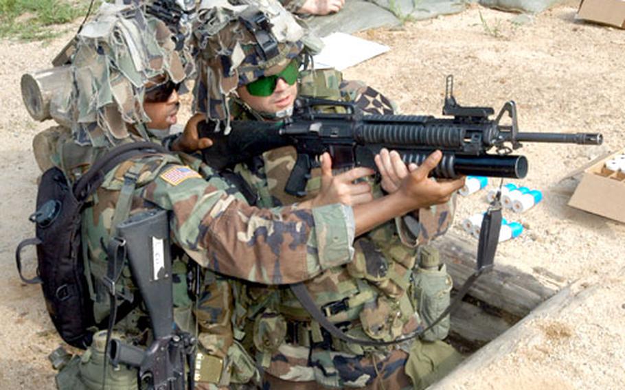 Pfc. Steven Luttrell, 21, of California fires an M-203 grenade launcher with the help of instructor Sgt. Derrick Palmer, 23, of Bronx, N.Y., at Cherokee Valley Range on Wednesday.