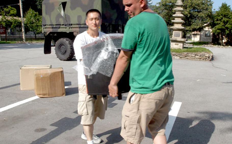 First Battalion, 38th Field Artillery Regiment soldiers Pfc. Lim Sang, 23, of Oakland, Calif., left, and Spc. Zachary Taylor, 24, of Cedar Rapids, Iowa, unload gear Tuesday at their new battalion headquarters at Camp Casey.
