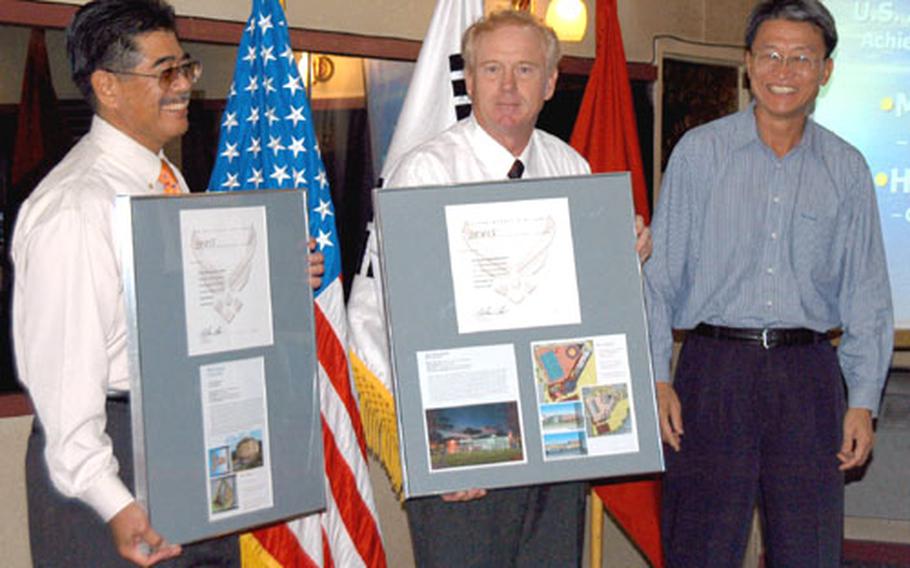 From left, Henry Miyamoto, David Doughtery and Paul Yoo accept two awards Thursday honoring the designs of an indoor swimming pool and housing facility at Osan Air Force Base in South Korea.