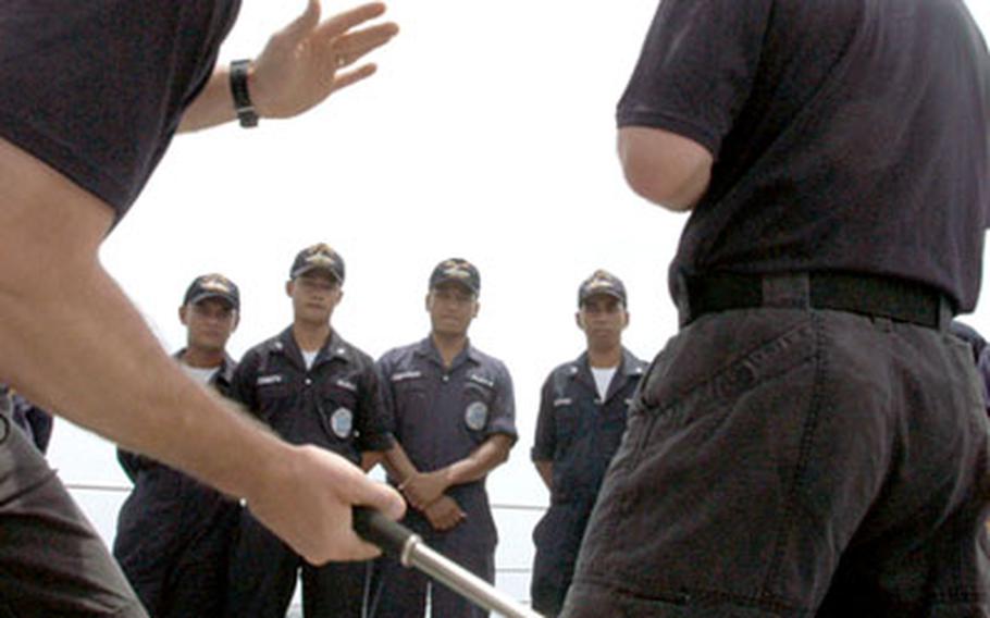 Members of the boarding team on the USS Rodney E. Davis demonstrate ways of using appropriate force Thursday when encountering an unruly person during a ship search.