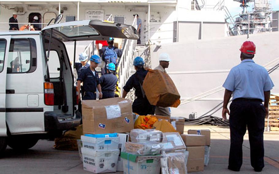 Sailors load mail Friday for USS Essex crewmembers onboard a barge on which many are living while the Essex undergoes maintenance, repairs and upgrades at Sasebo Naval Base, Japan.