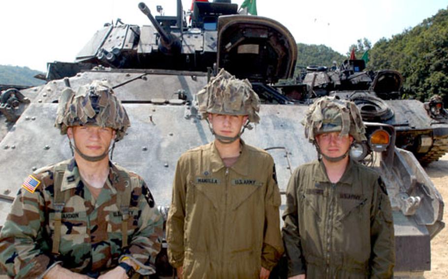 From left: Capt. Mike Reardon, 32, of San Antonio, Spc. Mark Manilla, 21, of Morgantown, W.Va., and Spc. Joshua Harris, 29, of Campton, Ky., all with the 2nd Battalion, 9th Infantry Regiment’s Company B, pose Wednesday with their Bradley Fighting Vehicle at Rodriguez Range, South Korea.