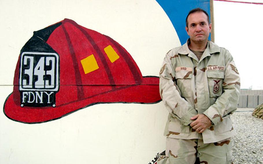 Staff Sgt. Gregg Magi poses at Ali Base, Iraq, with a mural remembering the 343 firefighters who lost their lives at Ground Zero trying to help victims of the Sept. 11, 2001, attacks. Magi is a firefighter with the 407th Expeditionary Civil Engineer Squadron and deployed from N.Y. Air National Guard’s 105th Airlift Wing.