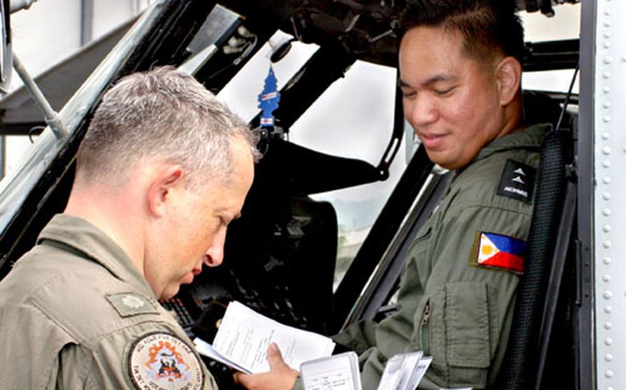 Lt. Cmdr. Kevin Klein, officer-in-charge of detachment 1 Helicopter Anti-Submarine Squadron (light) 45, explains SH-60B aircraft systems to a Philippine navy pilot during the Philippines phase of exercise Cooperation Afloat Readiness and Training 2005.