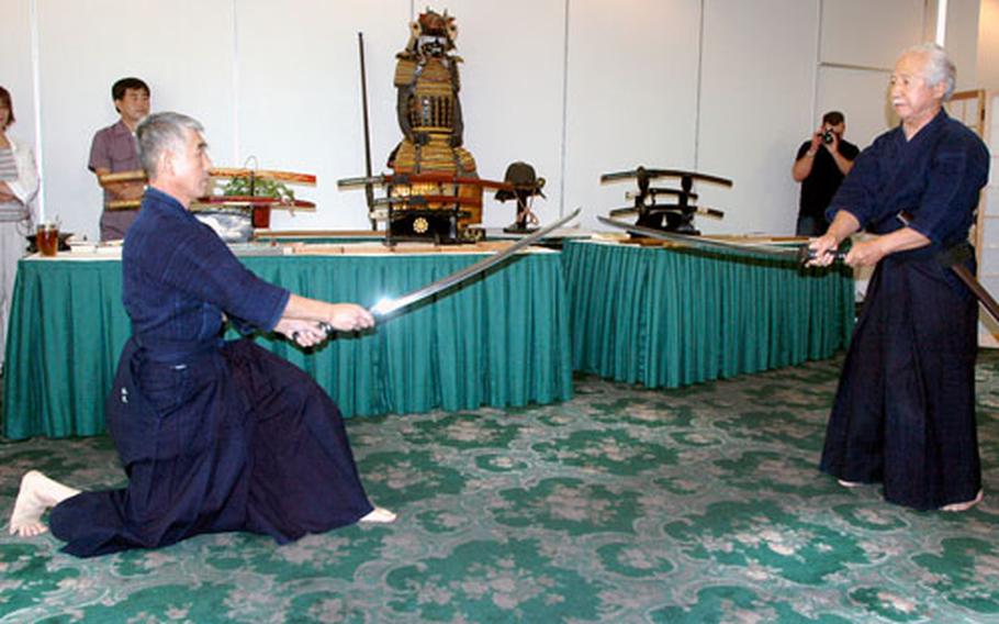 Ikuo Matsuo, at left, a fifth degree kendo master, and his teacher, eighth degree kendo master Tsuyoshi Fukugawa, demonstrate some of the moves used in this fighting technique on Sunday afternoon at Sasebo Naval Base’s Harbor View Club.