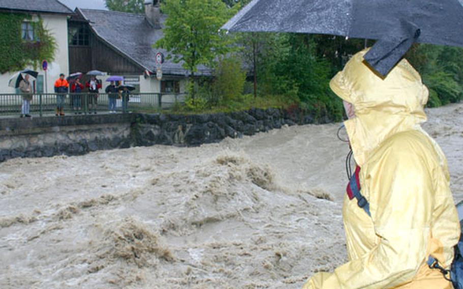 Onlookers watch the Loisach River rush through the village of Garmisch, Germany, on Tuesday.