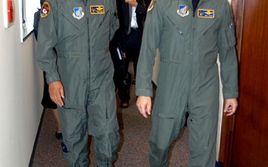 Mayor Shigeyoshi Suzuki, left, and Brig. Gen. Bill Rew walk down the hall at wing headquarters Tuesday on their way to address a group of first-term airmen.