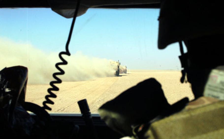 Tractor-trailers kick up sand and dust Friday en route to Command Outpost Rawah.