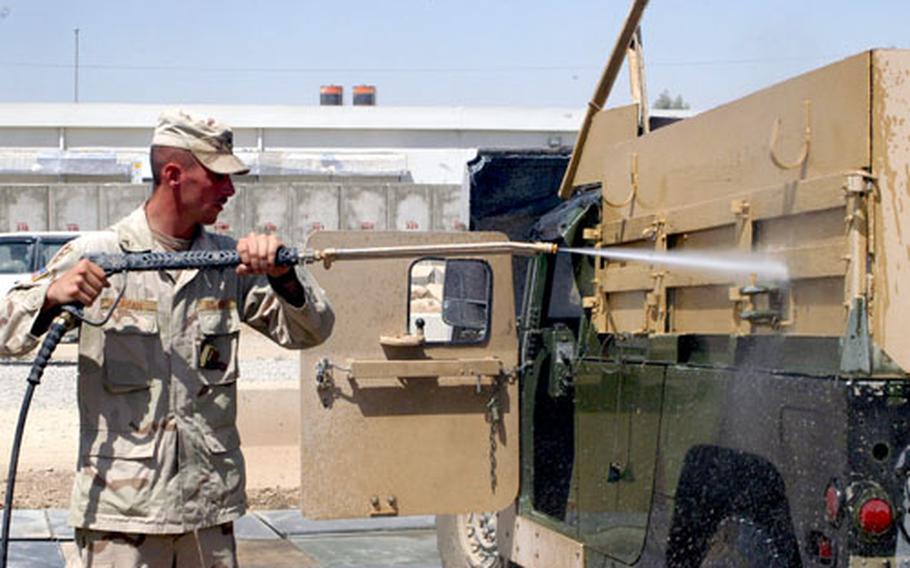 Cpl. Walter Morgan of the 535th Engineer Company (Combat Support Equipment) washes his Humvee with a pressure sprayer Thursday at Forward Operating Base Marez in Mosul, Iraq. Some of the soldiers’ daily duties, like this one, help them cool down a little as summer temperatures climb up to 120 degrees.