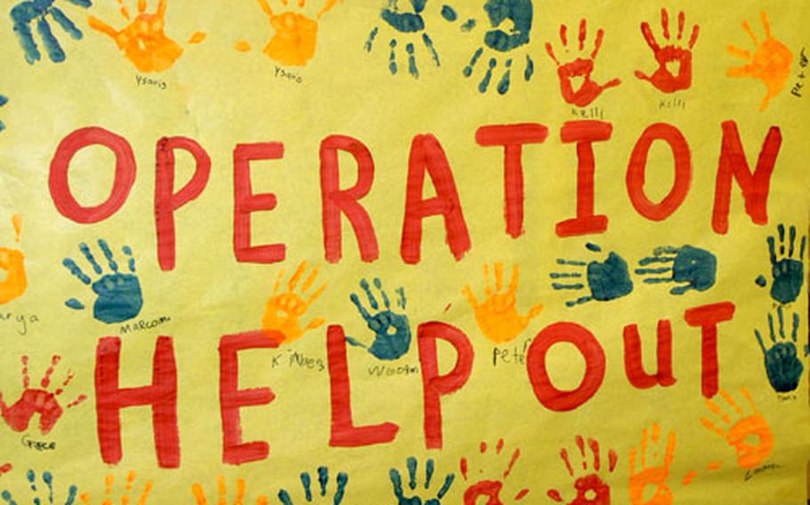 Members of the Promise Passport Club dipped their hands in paint to help decorate this sign publicizing Operation Help Out, an effort to gather lollipops, shoes and warm clothes for children in Afghanistan.