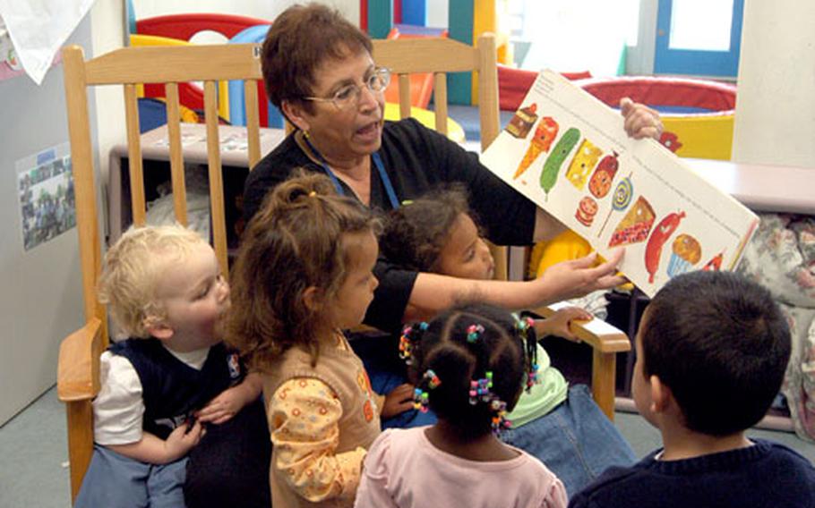 Adding her own sound effects to a story, Linda Vogt reads a book to 2- and 3-year-olds at the Child Development Center in Darmstadt, Germany. A shortage of caregivers at many Army Child and Youth Services programs in Germany and Italy has led officials to hire local nationals as providers.