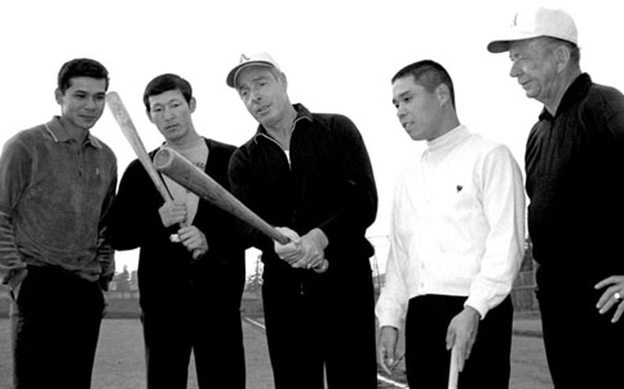 Joe DiMaggio, second from left, gives batting tips to (left to right) Marcelino Agcaoili, Isao Itoh and Shozo Shigematsu of the Taiyo Whales. At right is Oakland A&#39;s pitching coach Bill Posedel.