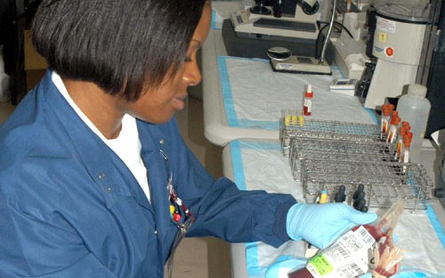 Petty Officer 2nd Class Stephanie Santiago, U.S. Naval Hospital Okinawa laboratory technician, prepares a sample of blood for testing. Santiago will be affected by the dental technician and hospital corpsman rate mergers.