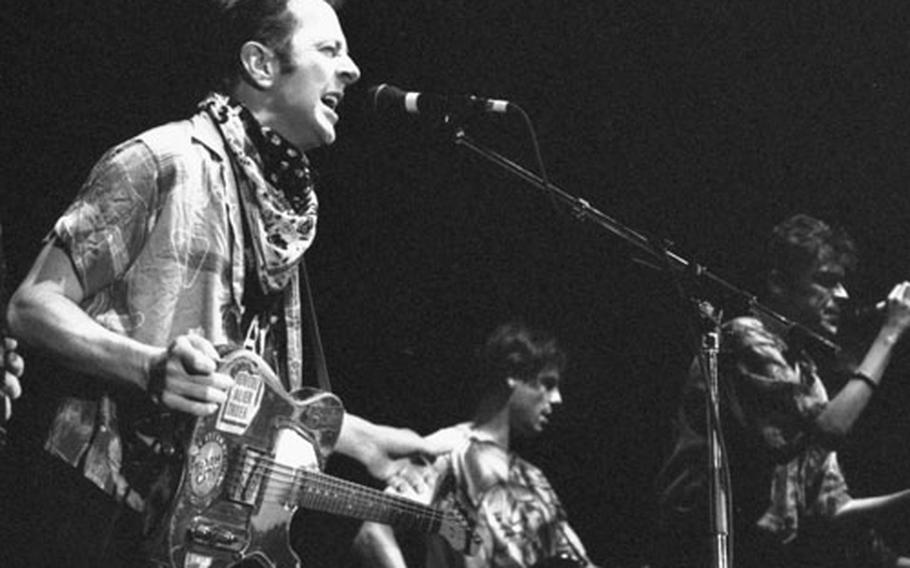 Joe Strummer, left, with Darryl Hunt and Spider Stacy of The Pogues in October, 1991.