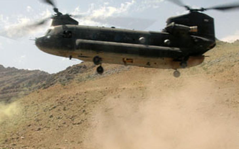 Soldiers from Company C, 2nd Battalion (Airborne), 503rd Infantry Regiment, turn and kneel away from a CH-47 Chinook helicopter as it comes in for a landing in a riverbed northwest of Qalat, Afghanistan, in July. A similar Chinook helicopter crashed southwest of Deh Chopan on Sunday, killing all five crewmembers.