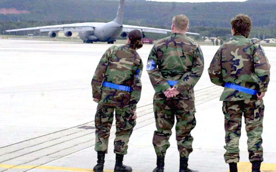 Airmen watch a C-141 Starlifter taxi before take off at Ramstein Air Base, Germany, on Friday.