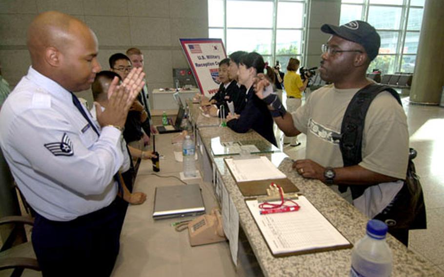 Air Force Staff Sgt. Hugh Archer, left, fields questions Saturday at the reception desk at Incheon International Airport, South Korea.