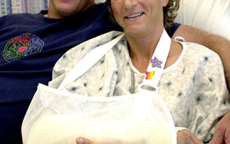 Jill Kleinheinz, a special education teacher with DODDS on Okinawa, sits with husband Bern Burkhalter in her hospital room at U.S. Naval Hospital Okinawa Friday afternoon. Kleinheinz collided with a car while riding her bike on her 40th birthday on Oct. 4.