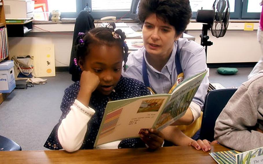 Lisa Heinzmann, a teacher at Kitzingen Elementary School, helps a student sharpen her reading skills in this 2002 photo. The school is one of three in the Würzburg-Kitzingen community that will be closing at the end of the current school year as part of the move of 1st Infantry Division troops to the States.
