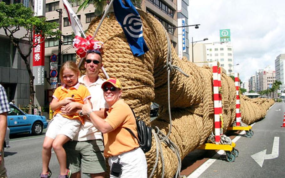 Marine Master Sgt. Russell Johnson and his wife, Katie, and daughter, Amber, pose before the Higashi, or East, end of the Naha Great Tug-of-War rope Sunday prior to the contest. Hundreds of American servicemembers and their family members took part in the contest.