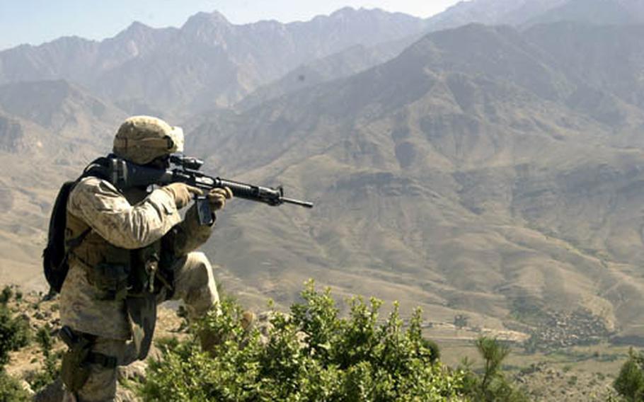 U.S. Marine Corps Staff Sgt. William Swinson, with Company F, 2nd Battalion, 3rd Marine Regiment, 3rd Marine Division, scans a ridgeline while climbing a 7,000-foot mountain in eastern Afghanistan last month.