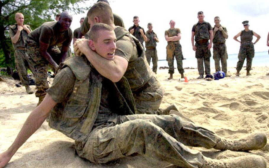Pfc. Joseph Maness, a military police patrolman from Camp Courtney, is put in a choke hold by fellow Camp Foster patrolman Lance Cpl. Jonathan Tufo during a grappling training session.