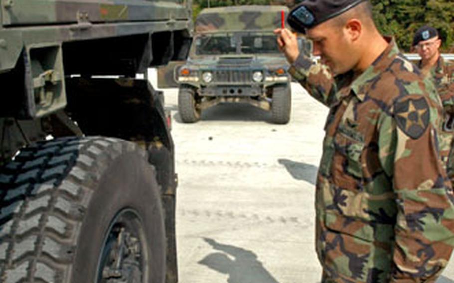 Company D, 1st Battalion, 2nd Aviation Regiment Apache helicopter mechanic Sgt. Travis Dalton weighs a Light Medium Tactical Vehicle at Camp Casey on Thursday.