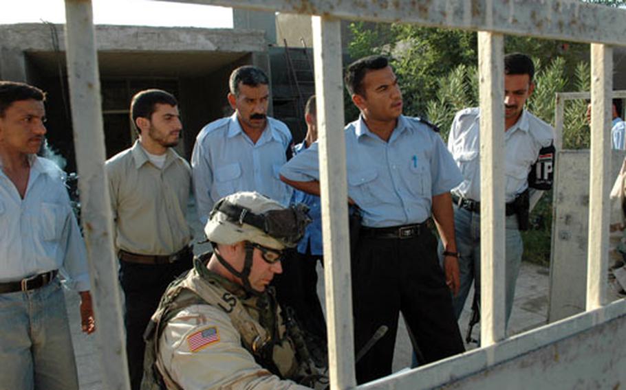 First Lt. Robert Peterson confers with Iraqi police and voting officials at a polling place in Muqdadiyah. Peterson was checking on final security precautions Friday.