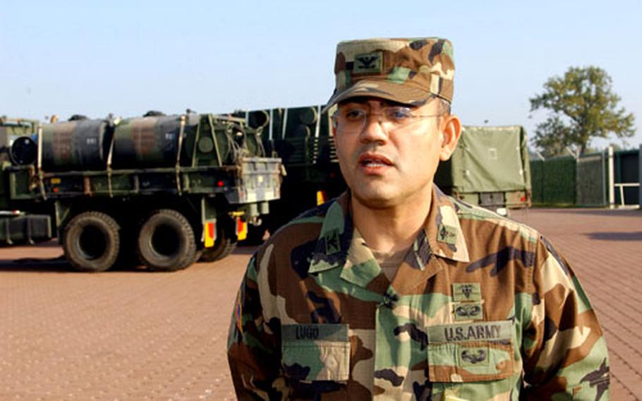 Col. Angel L. Lugo, Task Force 212 commander, stands before some of the many vehicles his unit will be taking to Pakistan to use in earthquake relief efforts.