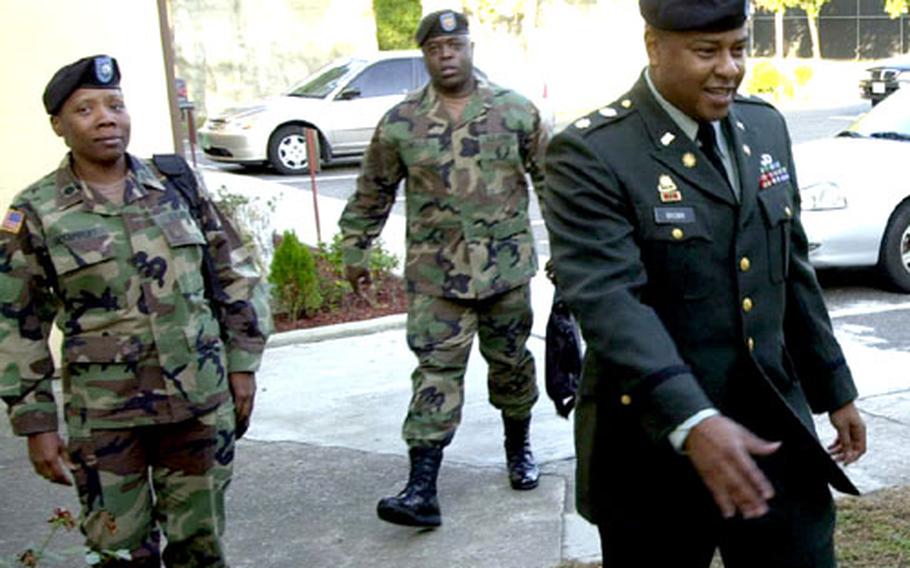 Maj. Jeffrey L. Brown, right, arrives at court Monday morning at Camp Henry, South Korea.