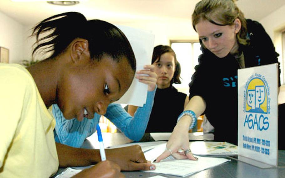 Gabby King, 14, left, makes a change to a script while Liz Parker, 14, looks on. The girls, both ninth-graders at Seoul American High School, are participating in skits that talk about the dangers of alcohol and smoking.