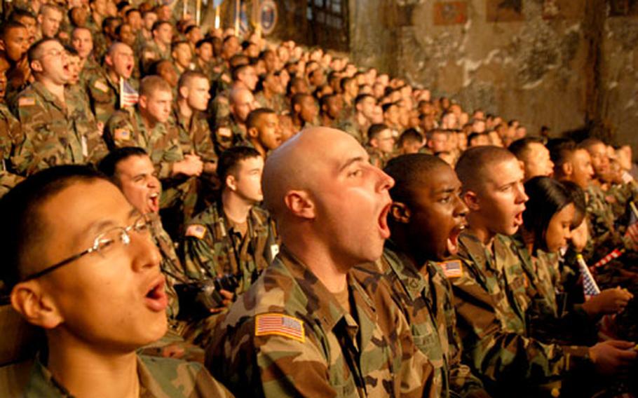 Soldiers with U.S. Forces Korea give a “hooah,” the Army’s traditional cheer, as they await the arrival of Defense Secretary Donald Rumsfeld. The soldiers had to wait about two hours for the secretary to arrive, and they sang songs, gave cheers and even did the wave during their wait.