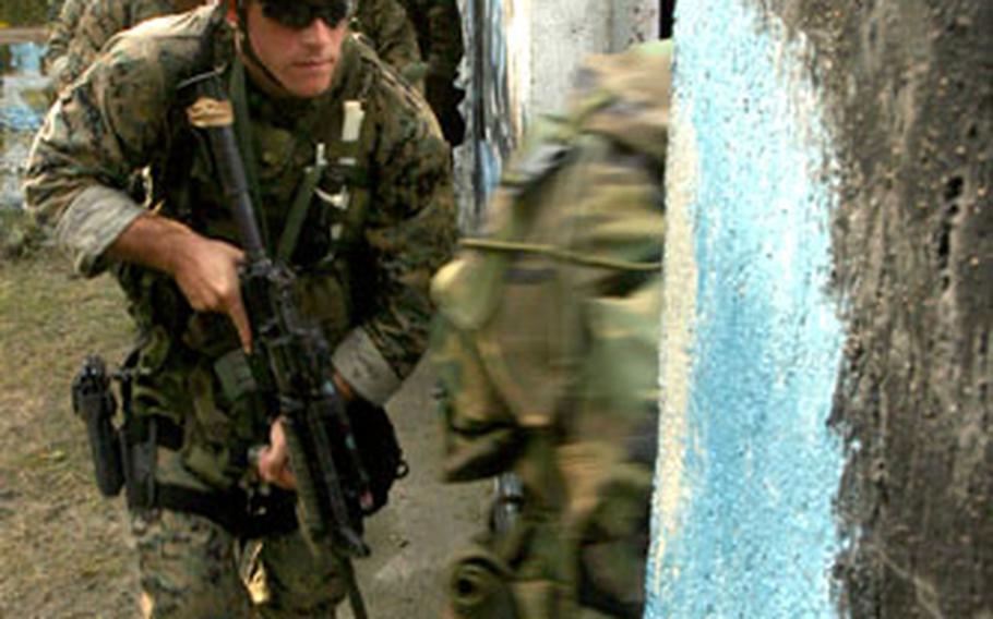 U.S. Marines assault a “kill house,” a simulated close-quarters battle training site, while Philippine marines and airmen observe and study during live-fire training at Clark Air Base in the Philippines on Tuesday.