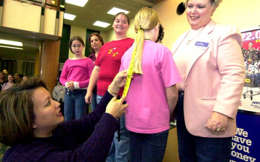 Anna Iosefo measures the hair of Richelle Baldwin, a 4th-grader at East Elementary School, Yokota Air Base, Japan, before she cuts it off Saturday morning to give to “Locks for Love” at Yokota Air Base, Japan. “Locks for Love” is a charity that supports cancer victims by making wigs out of donated hair.