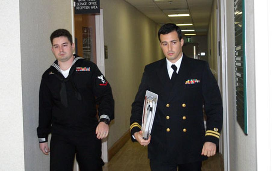 Petty Officer 3rd Class David Fail, left, walks to the courtroom with his lawyer, Lt. Michael Arcati, at Naval Support Activity Naples, Italy, on Monday morning.