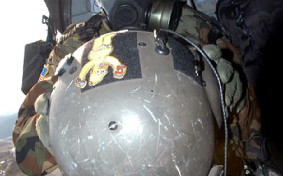 A Company C, 2nd Battalion, 2nd Aviation Regiment soldier dons NBC (nuclear, biological and chemical) protective gear at Rodriguez Range on Monday.