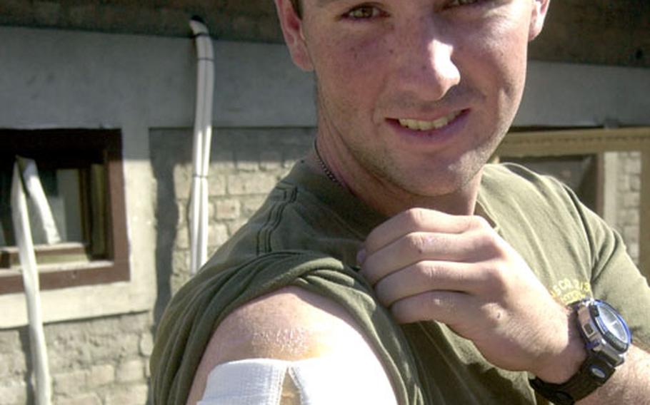 U.S. Marine Corps Lance Cpl. John McClellan, with Company E, 2nd Battalion, 3rd Marine Regiment, 3rd Marine Division, out of Kaneohe Bay, Hawaii, displays bandages over the entrance and exit gunshot wounds he received in his right shoulder after being shot earlier this month. McClellan, 19, of Columbia, Mo., also was shot in his right wrist just days before he was shot in his right shoulder.