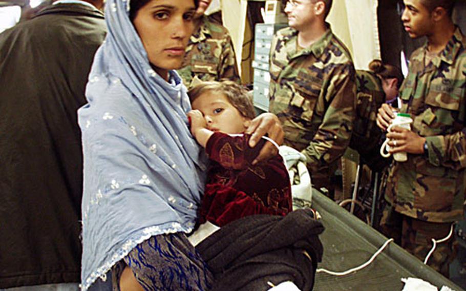 Aribba Abbasi, 2, is held by her mother in the 212th MASH in Muzaffarabad, Pakistan. Aribba’s parents walked for two days to ask doctors to check her broken leg, an injury from the Oct. 8 earthquake. She and an 8-year-old boy were the MASH’s first patients Tuesday morning, the day after the unit arrived.