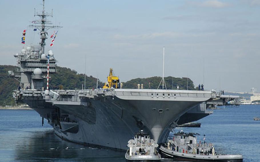 Assisted by two harbor tug boats, the USS Kitty Hawk steams away from the pier at Yokosuka Naval Base, Japan, to begin its fall underway period. Navy officials announced Friday the Kitty Hawk will be replaced in 2008.