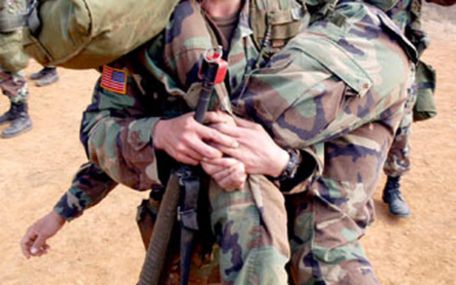 121 General Hospital soldier Spc. Maria Slaughter, 29, of Jacksonville, N.C, carries “patient” Rick Urban of the 302nd Brigade Support Battalion during EFMB training at Warrior Base in South Korea on Thursday.