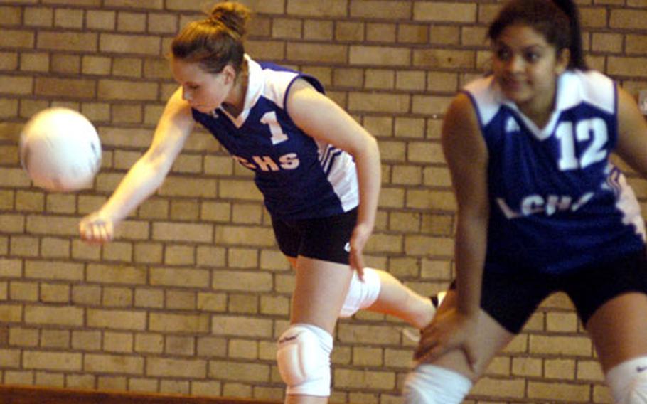 London Central setter Sara Lijewski serves during a game with Lakenheath on Saturday as outside hitter Micana Gallaway waits for the return. London Central defeated Lakenheath in five sets.