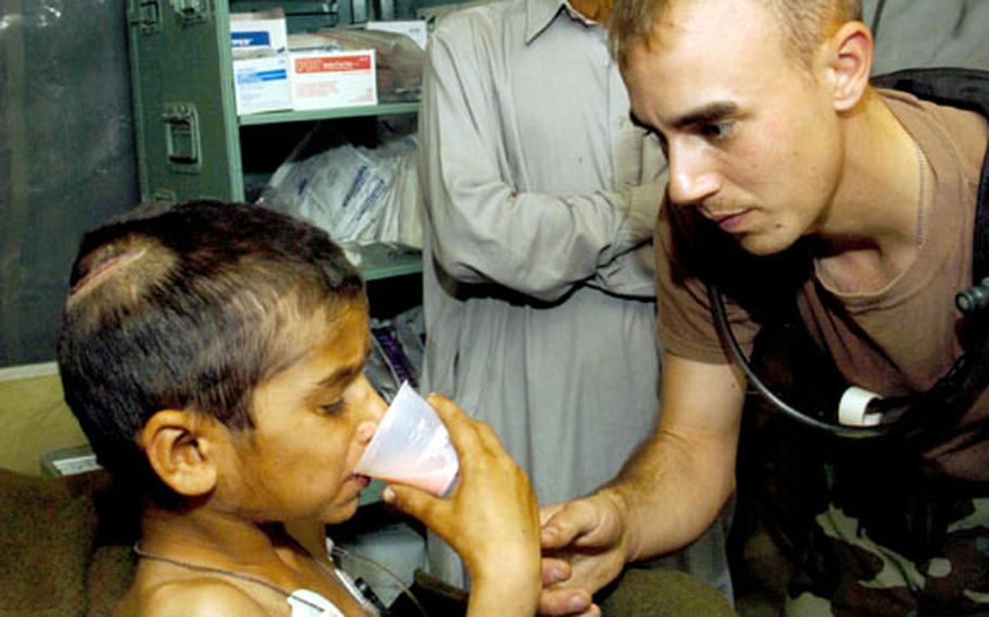 1st Lt. Tory Marcon helps Riaz Sharif drink the only food tetanus patients at the 212th MASH can manage to swallow because of muscle spasms: a powdered milkshake from the MREs.