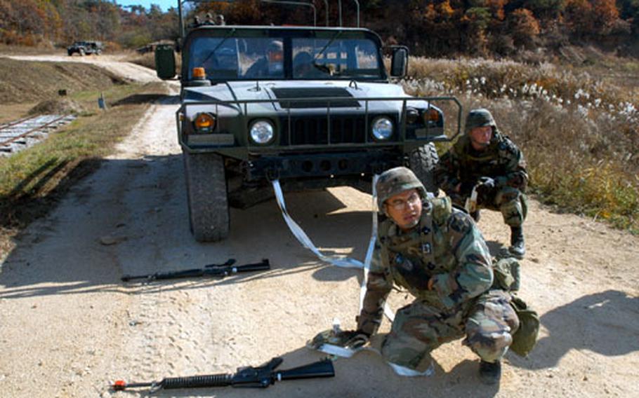 Company A, 602nd Aviation Support Battalion soldiers hitch a “damaged” Humvee to a Light Medium Tactical Vehicle during Monday’s training.