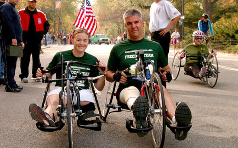 Retired Army 1st Lt. Melissa Stockwell, left, and Army Staff Sgt. Joe Bowser check out their hand-crank chairs before a training session Saturday in New York City’s Central Park. The two are members of the Achilles Track Club and will be competing in Sunday’s New York City Marathon.