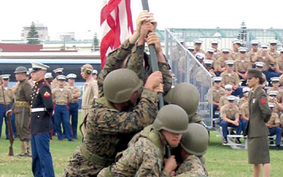 Marines re-enact the raising of the flag on Mt. Suribachi during the Battle of Iwo Jima at the Marines Corps 230th birthday celebration on Camp Foster, Okinawa, on Thursday.